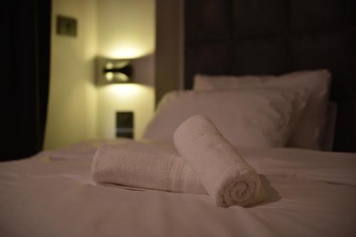 a stack of towels sitting on a bed at Selfie's Boutique Hotel in Tiberias