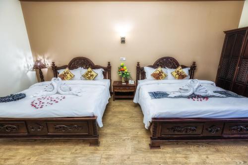 a bedroom with two beds with white sheets at Bali Hotel in Phnom Penh