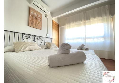 a bed with a stuffed animal sitting on top of it at Hostal El Castillo in Arenas de San Pedro