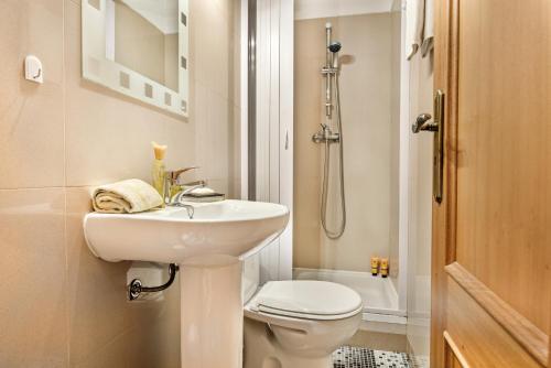 a white bathroom with a sink and a toilet at Apartment Galé Garden 1A in Albufeira