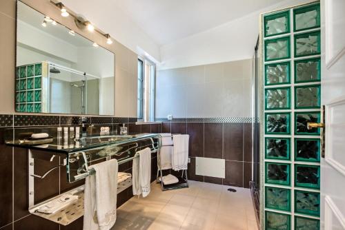 une salle de bain avec un lavabo et un grand miroir dans l'établissement Buganvilia by Algarve Villa Holidays, à Guia