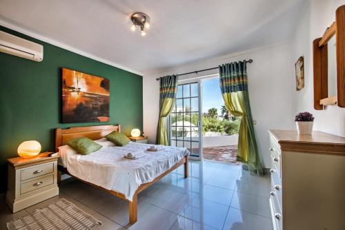 1 dormitorio con 1 cama con pared verde en Villa Buganvilia, en Guia