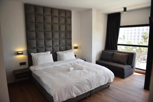 a bedroom with a large bed and a chair at Selfie's Boutique Hotel in Tiberias