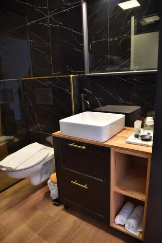a bathroom with a sink and a toilet and a mirror at Selfie's Boutique Hotel in Tiberias
