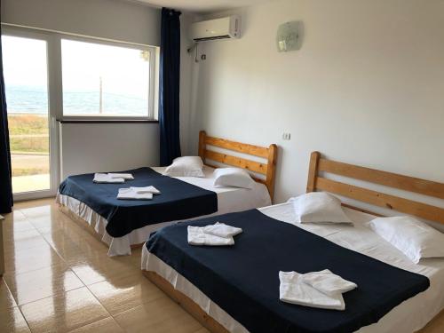 - 2 lits dans une chambre avec des serviettes dans l'établissement Autentic Boutikue, à Costinesti