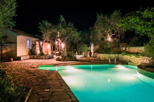 a swimming pool in a yard at night at Irida Cottage in Vlachopoulátika