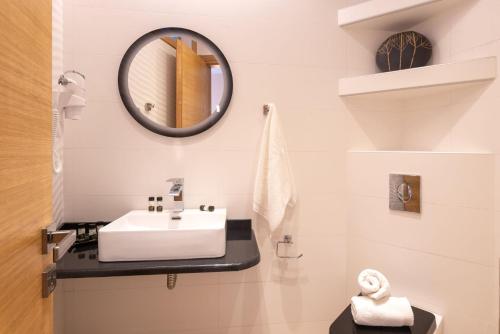 a bathroom with a sink and a mirror at Panorama Exclusive Suites in Parga