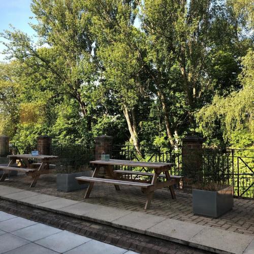 two picnic tables in a park next to a fence at Novotel York Centre in York