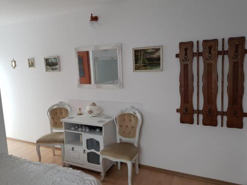 1 dormitorio con 2 sillas, mesa y espejo en Zajazd Ponikiew - Noclegi Wadowice, en Wadowice
