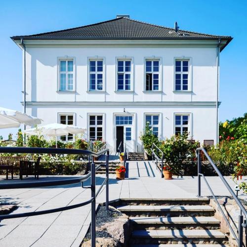 a large white house with stairs in front of it at Gutshaus Groß Helle in Mölln