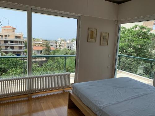 1 dormitorio con cama y ventana grande en OASIS Exclusive Apartment @ Athenian Riviera, en Atenas