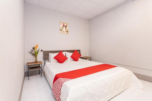 Dormitorio blanco con cama con almohadas rojas en Colorful Home Stay Phú Quốc, en Phu Quoc