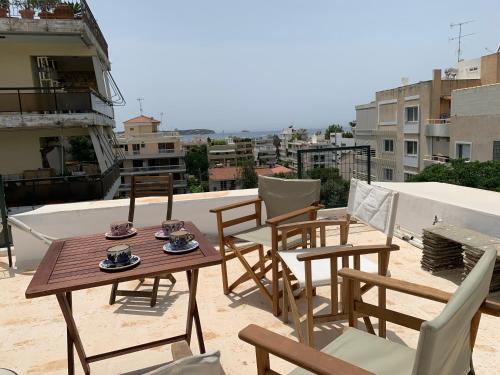 una mesa y sillas en la azotea de un edificio en OASIS Exclusive Apartment @ Athenian Riviera, en Atenas