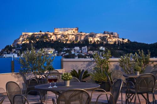 a patio with tables and chairs with a view ofhens at Arion Athens Hotel in Athens