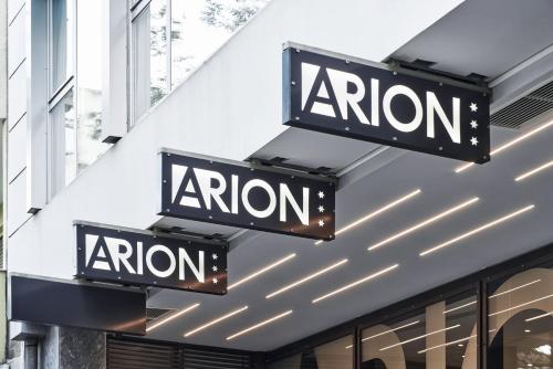 two signs on the side of a store at Arion Athens Hotel in Athens