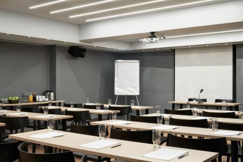 an empty lecture room with tables and chairs at Arion Athens Hotel in Athens