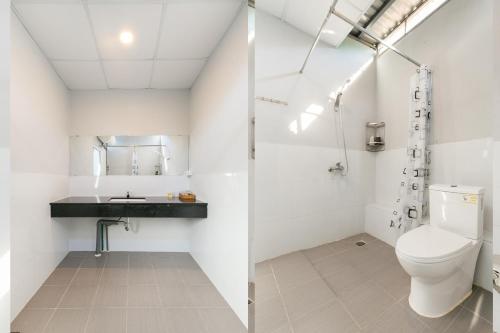 Baño blanco con aseo y lavamanos en Colorful Home Stay Phú Quốc en Phu Quoc