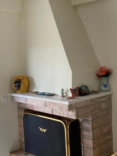 a living room with a stone fireplace with a tv at Stella Maisonette Hanioti in Hanioti
