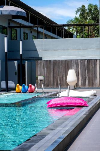 a swimming pool with colorful pillows in the water at S Ratchada Leisure Hotel in Bangkok