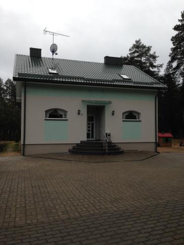 a large white building with a brick driveway at El Arm El in Druskininkai