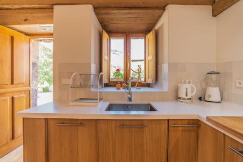una cocina con armarios de madera y fregadero en Terra Ecoturismo Casa La Laguna, en La Focella