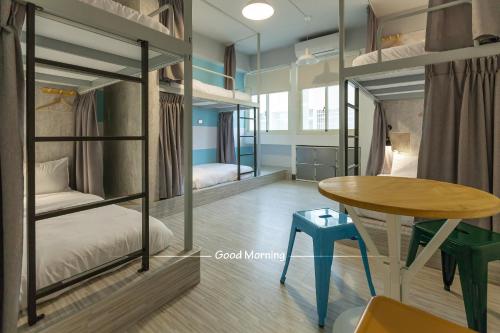 a room with two bunk beds and a table at Bayhouse Comfortel Hualien Hostel in Hualien City