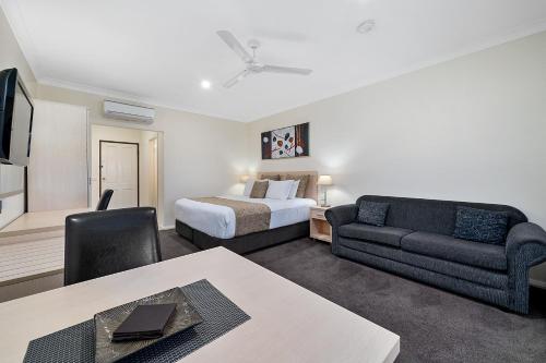 een hotelkamer met een bed en een bank bij Heritage Motor Inn Corowa in Corowa