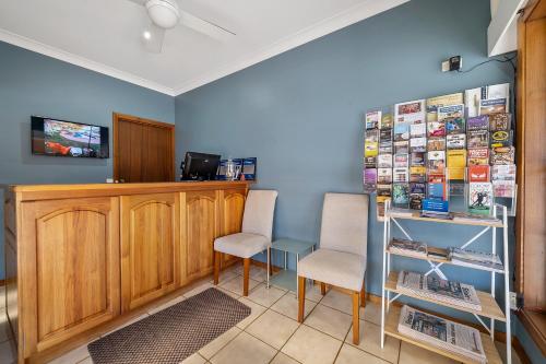 a living room filled with furniture and a tv at Heritage Motor Inn Corowa in Corowa