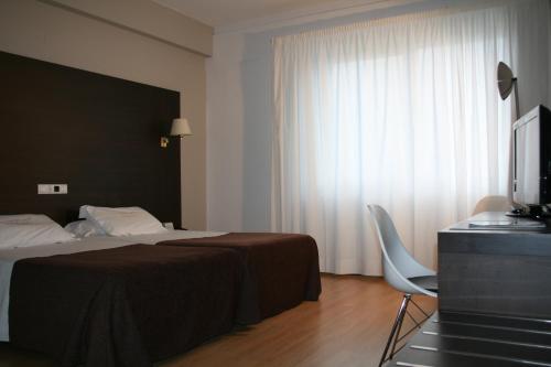 Un pat sau paturi într-o cameră la Hotel Mendez Nuñez