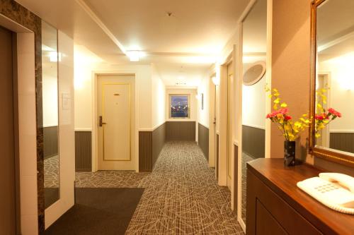 a hallway of a bathroom with a sink and a mirror at Hotel Hokke Club Kagoshima in Kagoshima