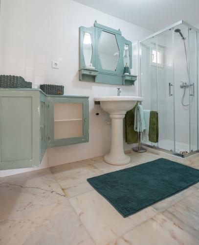 a bathroom with a sink and a glass shower at Casa dos Castanheiros in Vila Verde