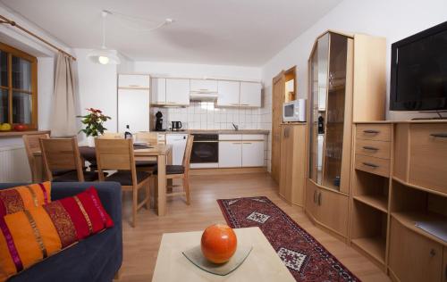 a kitchen and living room with a couch and a table at Appartementhaus Erasim in Schladming