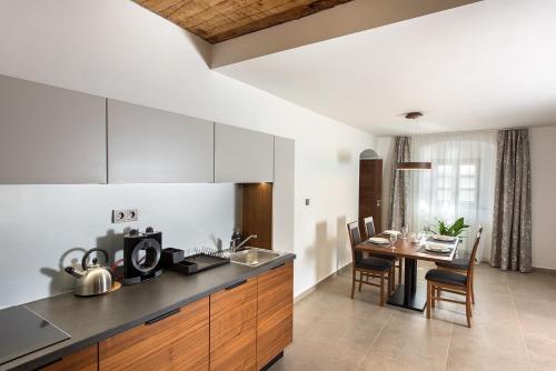 a kitchen with a table and a dining room at Residence Hluboká in Hluboká nad Vltavou