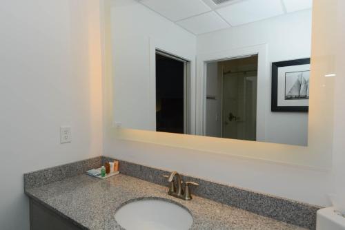 a bathroom with a sink and a large mirror at Avenue Inn & Spa in Rehoboth Beach