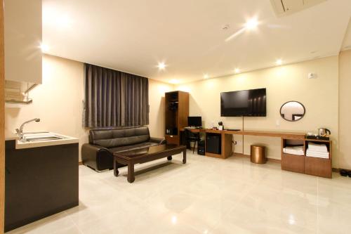 a hotel room with a couch and a television at The King Hotel in Busan