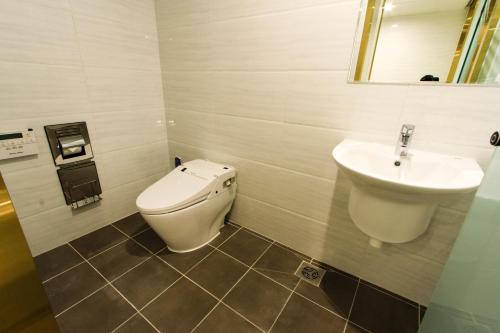 a bathroom with a toilet and a sink at The King Hotel in Busan
