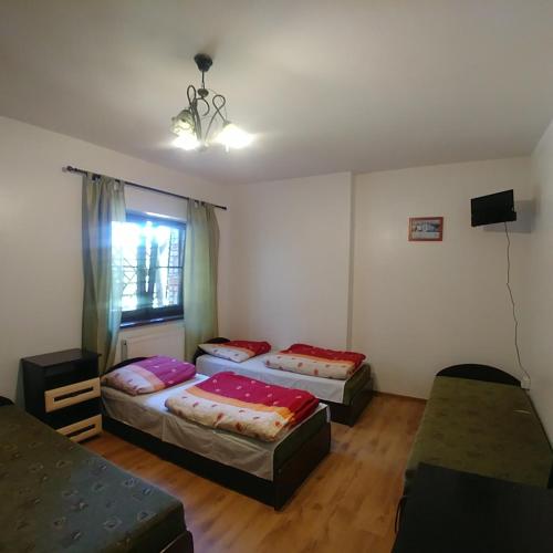 a bedroom with two beds and a window at RANCHO-JURA in Podlesice