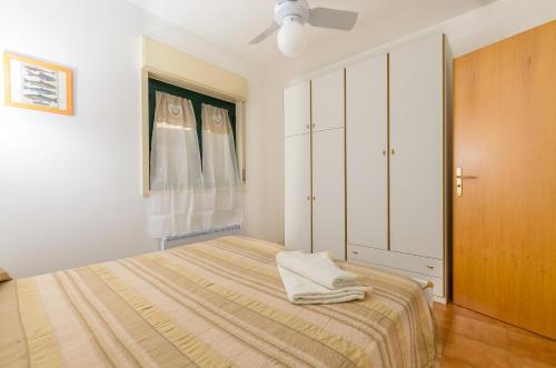 - une chambre blanche avec un lit et un placard dans l'établissement La Gardenia Apartment, à Taormine