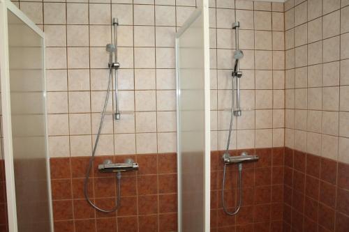 a bathroom with a shower with two shower heads at Labbnäs Semesterhem in Kimitoön