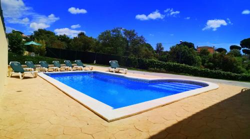 a swimming pool with lounge chairs next to it at Villa Fradera in Lloret de Mar