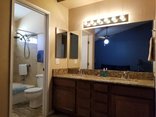 a bathroom with a sink and a toilet and a mirror at Quiet Neighborhood off La Canada in Tucson