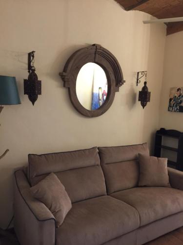 salon z kanapą i lustrem w obiekcie Tuscany Heba w mieście Magliano in Toscana
