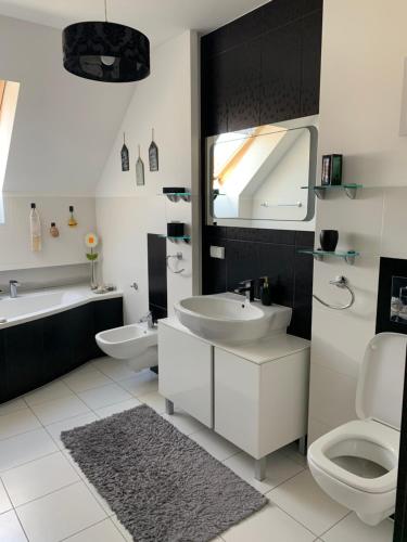 a bathroom with two sinks and a toilet and a mirror at Silver Mazury Apartament in Giżycko