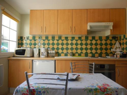 a kitchen with a table and a table and chairs at Calme et verdure en plein coeur d Illiers Combray in Illiers