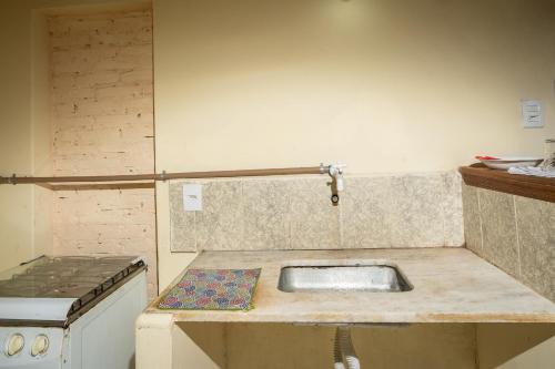 uma cozinha com um lavatório e um fogão em Pousada Pantanal em Ladário
