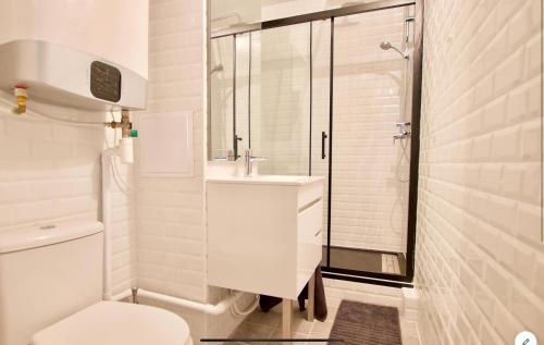 a white bathroom with a shower and a toilet at Joli studio ☆ 100m de la mer et du centre ville ☆ in Cabourg