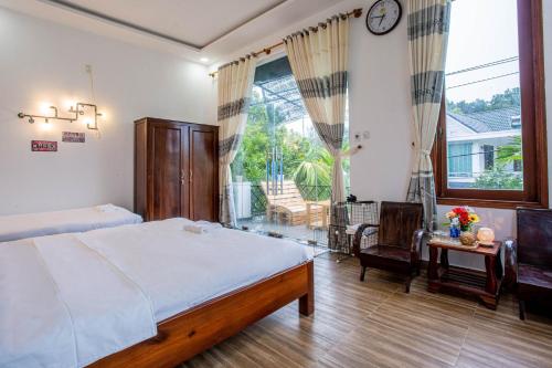 顺化Lam Vien Homestay Hue的一间卧室，配有一张床、一张书桌和一扇窗户