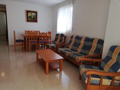 a living room with couches and a table and chairs at Parquemar VIII Solo Familias Serviplaya in Xeraco