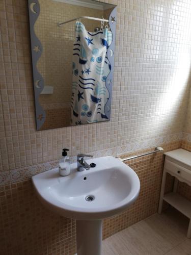 a bathroom sink with a mirror and a shower curtain at Parquemar VIII Solo Familias Serviplaya in Xeraco