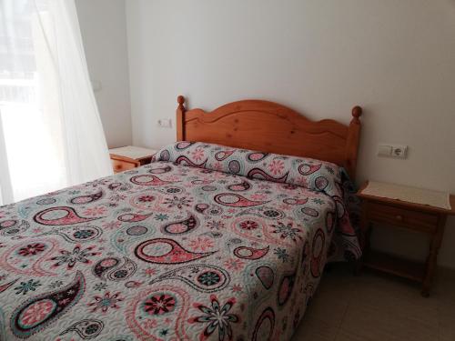 a bedroom with a bed with a colorful bedspread at Parquemar VIII Solo Familias Serviplaya in Xeraco